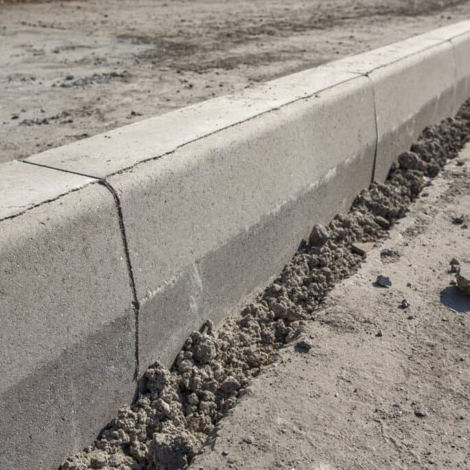 Sidewalk under construction, concrete curb  installation in progress.